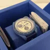 A watch is placed inside a blue box, with some papers next to it. Náhled obrázku produktu