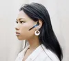A woman wearing a white shirt and a Bluetooth headset. Produktbild-Vorschau