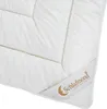 A close-up view of a white comforter with a label attached to the corner. Produktbild-Vorschau
