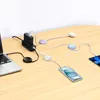 Multiple charging devices and cables connected to a laptop and tablet on a wooden desk. Anteprima dell’immagine prodotto
