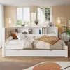 A white daybed with a built-in bookshelf is set up in a bedroom with two windows and a rug on the floor. Náhled obrázku produktu
