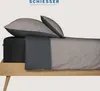 A bed with bedding, including pillows and a fitted sheet, arranged neatly. Produktbild-Vorschau