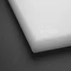 A close-up view of the corner of a white cutting board with some symbols embossed on it. Produktbild-Vorschau