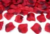 A pile of dark red fabric rose petals scattered on a white background. Podgląd zdjęcia produktu