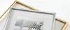 Two picture frames, one gold and one silver, are shown overlapping each other against a white background. The silver frame is in the foreground and contains a picture of a sofa with pillows. Produktbild-Vorschau