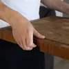 A person is holding a wooden cutting board. Produktbild-Vorschau
