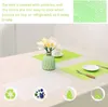 A table setting with placemats, a vase of flowers, and place settings. Produktbild-Vorschau