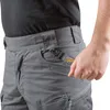 Close-up shot of a person's hip area wearing gray tactical pants. Náhled obrázku produktu