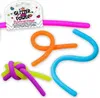 Several glittery, flexible tubes are arranged on a white background. One pink tube is partially visible at the top, connected to a tag. Three other tubes are in the foreground: one orange, one blue, and a knot of purple and yellow/green tubes. Produktbild-Vorschau