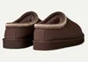 A pair of brown UGG Tasman II slippers are shown from a rear, slightly elevated angle against a plain light gray background. Anteprima dell’immagine prodotto