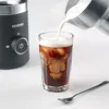 Pouring frothed milk into a glass of iced coffee next to a milk frother. Produktbild-Vorschau