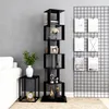 A black shelving unit with decorative items and books, next to a white sofa and a small black side table with a clock. Produktbild-Vorschau