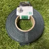 A roll of green garden tape on a spool, placed on artificial grass. Voir les images du produit