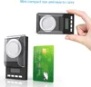 A hand holding a small digital scale next to a credit card, illustrating its compact size. Podgląd zdjęcia produktu