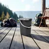 A dark gray camping bucket with a lid and handle sits on a wooden deck outdoors, with a scenic view of mountains and trees in the background. Anteprima dell’immagine prodotto