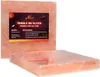 Two pink Himalayan salt blocks for grilling, one with a label. Produktbild-Vorschau