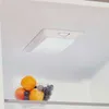 A close-up view inside a refrigerator, showing a bowl of fruit and the interior light. Produktbild-Vorschau