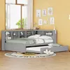 A child's bedroom with a grey sofa bed and trundle, featuring a bookshelf headboard and decorative wall art. Voir les images du produit