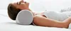 A woman lying on her back with a cylindrical pillow supporting her neck. Produktbild-Vorschau
