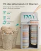 A person's hand is shown opening the lid of a large gray laundry basket with two compartments, which is filled with folded laundry. Two wicker baskets filled with laundry are in the foreground. Produktbild-Vorschau