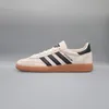 A side view of an Adidas Handball Spezial shoe against a plain gray background. Voir les images du produit