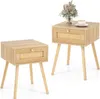 Two identical wooden nightstands with rattan drawer fronts are shown against a white background. One nightstand has a small vase with dried flowers and a cup of coffee on top.