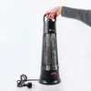 A hand holding a black electric heater. Produktbild-Vorschau