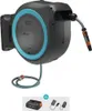 A wall-mounted hose reel with a hose and nozzle, along with a battery and charger accessory. Voir les images du produit