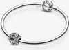 A silver Pandora bracelet with two charms, one of which is a clasp with the Pandora logo, and the other is an openwork charm featuring celestial motifs. Produktbild-Vorschau
