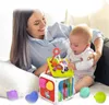 A mother and baby are playing with a colorful activity cube toy. Produktbild-Vorschau