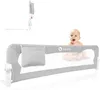 A baby is peeking over a grey bed rail on a white background. Podgląd zdjęcia produktu