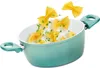 A teal pot with pasta and parsley being tossed into it. Anteprima dell’immagine prodotto