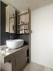 A modern bathroom with a sink, vanity, and a closed door. Produktbild-Vorschau
