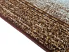 A close-up, angled view of the edge of a rug with a textured pattern. Náhled obrázku produktu
