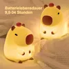 Two illuminated capybara-shaped night lights are placed on a bed. Produktbild-Vorschau