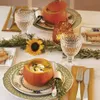 A beautifully set table for a festive meal, featuring pumpkins as serving dishes and decorative elements. Produktbild-Vorschau