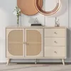 A light-colored sideboard with rattan doors and three drawers, displayed in a well-lit room. Voir les images du produit