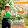 A woman watering plants in a raised garden bed with a greenhouse lid. Produktbild-Vorschau