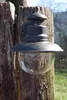 A rustic outdoor wall lamp mounted on a weathered wooden post. Produktbild-Vorschau