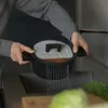 A person is rinsing a pot in a sink. Podgląd zdjęcia produktu