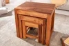 A set of three nesting wooden tables on a carpeted floor. Produktbild-Vorschau