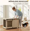 A woman is interacting with a wooden dog crate that has wheels, in a room. Náhled obrázku produktu