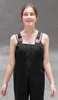 A young person wearing a black uniform with suspenders. Produktbild-Vorschau