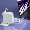 A white USB-C power adapter plugged into a wall socket, connected by a white cable to a laptop. Produktbild-Vorschau