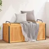 A wooden storage box with cushions and a blanket on top, placed on a wooden deck. Voir les images du produit