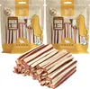 Two bags of dog treats and a pile of dog treats in front of them. Produktbild-Vorschau