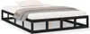 A black wooden bed frame with a white mattress and a beige and white patterned blanket. Produktbild-Vorschau