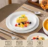 A table setting with a slice of cake and fruit on a plate, a glass of wine, and cutlery. Produktbild-Vorschau