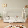 A child's bedroom with a white house-shaped bed frame decorated with fairy lights. Náhled obrázku produktu