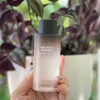 A hand holding a bottle of Haruharu Wonder Black Rice Hyaluronic Toner in front of a blurred background of plants. Anteprima dell’immagine prodotto